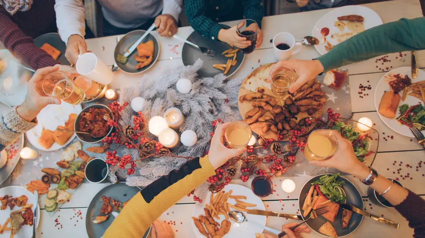 Photo of a multi generation family during Thanksgiving dinner, spending time together over eaten food and messy plates
