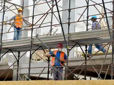 EMERGENZA CORONAVIRUS CORONA VIRUS COVID19 COVID 19.FASE 2 DUE.RIPRENDE L' EDILIZIA.CANTIERE DI EDILIZIA ABITATIVA.CANTIERI EDILI.OPERAIO OPERAI SICUREZZA SUL LAVORO.MASCHERINA PROTETTIVA MASCHERINE PROTETTIVE CASCO PROTETTIVO CASCHI PROTETTIVI ELMETTO ELMETTI.IMPALCATURA IMPALCATURE