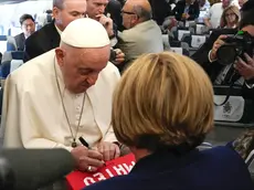 epa11580735 Pope Francis (L front) signs autographs on a cloth for a journalist, aboard the flight bound for Jakarta, the first stop of his Apostolic Journey to Southeast Asia, 02 September 2024. Pope Francis is set to begin his 12-day visit to four countries in Asia and Oceania. During his 45th Apostolic Journey, the Pontiff will visit Indonesia, Papua New Guinea, East Timor and Singapore until 13 September 2024. The Pope will clock 32,814 kilometers (20,390 miles) by air during his 02-13 September visit to Indonesia, Papua New Guinea, East Timor and Singapore, far surpassing any of his previous 44 foreign trips and notching one of the longest papal trips ever, both in terms of days on the road and distances traveled. EPA/GREGORIO BORGIA / POOL