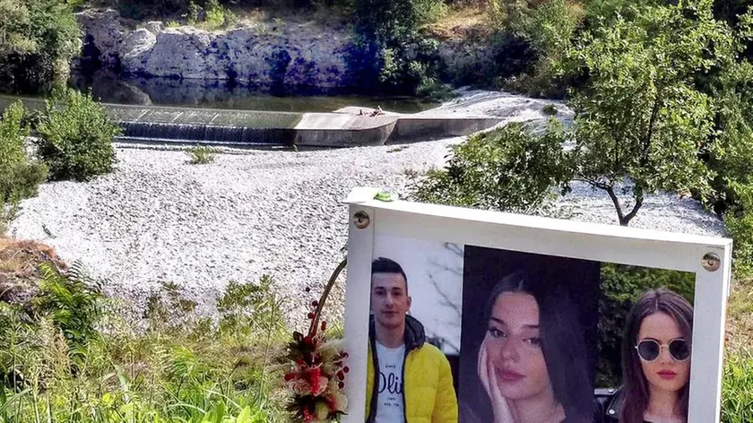 Le foto di Cristian, Bianca e Patrizia incastonate in una cornice bianca nel luogo dove familiari e amici hanno scrutato per giorni il fiume Natisone (foto Petrussi)