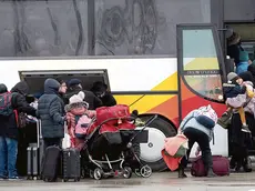 Refugees fleeing war in Ukraine board a bus as they arrive to Palanca, Moldova, Tuesday, March 1, 2022. (AP Photo/Aurel Obreja)