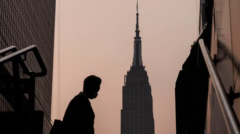 epa10677506 The Empire State Building stands in the background as a person wearing a mask walks on a hazy morning due to smoke from wildfires burning in Canada, in New York, USA, 07 June 2023. An air quality alert was issued for the whole of New York City as a result of the smoke, which affects large portions of the northeastern United States. EPA/JUSTIN LANE