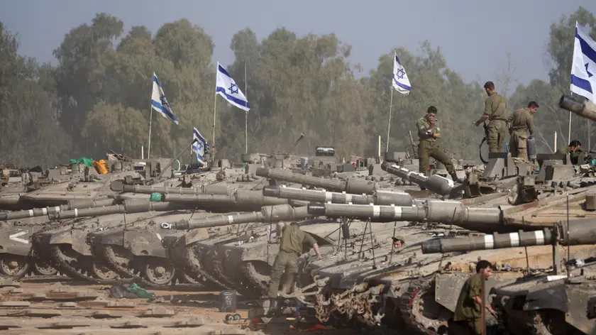 epa11052117 Israeli soldiers with their tanks gather at a position near the border with the Gaza Strip, in southern Israel, 01 January 2024. More than 21,600 Palestinians and at least 1,300 Israelis have been killed, according to the Palestinian Health Ministry and the Israel Defense Forces (IDF), since Hamas militants launched an attack against Israel from the Gaza Strip on 07 October, and the Israeli operations in Gaza and the West Bank which followed it. The Israeli military stated that its ground, air, and naval troops are 'continuing to conduct joint combat' across the Gaza Strip. EPA/ABIR SULTAN