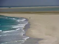 epa03638064 A picture made available 23 March 2013 shows a Yemeni fisherman walking on white sands on the shore of the island of Socotra, in the Indian Ocean, Yemen, 14 March 2013. The island of Socotra is situated in the Indian Ocean, some 250 miles off the coast of Yemen. It is the largest island in the Middle East and is known to the world as one of the best sites to witness biodiversity. During the monsoon season, which lasts from late May until late September each year, extremely high winds blow white sand dunes from Socotra's beautiful unspoiled beaches into nearby escarpments and hills. EPA/YAHYA ARHAB