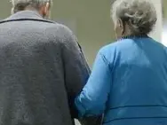 An elderly couple walk down a corridor in the pro vita Haus Rheingold nursing home for the elderly in Berlin, Germany, 5 December 2012. Photo: Jens Kalaene - Infophoto