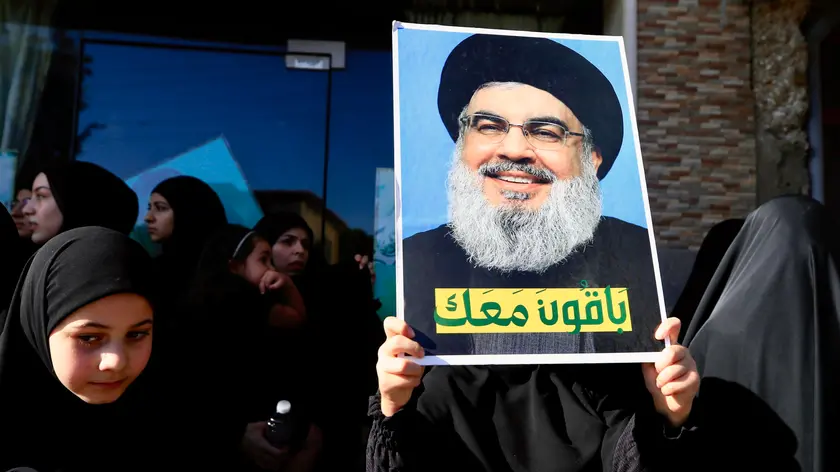 epa11598758 A woman holding a photo of Hezbollah leader Hassan Nasrallah and Arabic inscription reading 'We are with you' attends the funeral procession of Hezbollah commander Mohammed Qassem Al Shaerin Sohmor town, Western Beqaa, southern Lebanon, 11 September 2024. The Israel Defense Forces (IDF) said Al Shaer, who served as a Hezbollah Radwan Force commander, was killed in an Israeli Air Force (IAF) strike on 10 September in the area of Qaraoun, in the western Beqaa. EPA/STR
