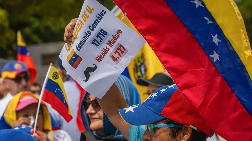 epa11569292 Protesters hold signs and flags during a demonstration organized by Venezuelan opposition leader Maria Corina Machado in front of the Basilica of Our Lady of Chiquinquira in Maracaibo, Venezuela, 28 August 2024. EPA/HENRY CHIRINOS