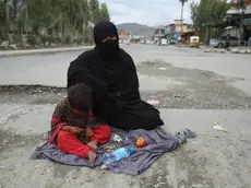 epa09136952 An Afghan woman begs for alms on a roadside in Jalalabad, Afghanistan, 15 April 2021. Civilian casualties in Afghanistan increased by 29 percent between January and March compared to the same period in 2020, despite an ongoing peace talks between the Taliban and the government, according to a report by the United Nations Assistance Mission in Afghanistan (UNAMA) on 14 April. UNAMA in its report also underlined a 37 percent increase in the number of women killed and injured, and a 23 percent increase in child casualties compared with the first quarter of 2020. EPA/GHULAMULLAH HABIBI