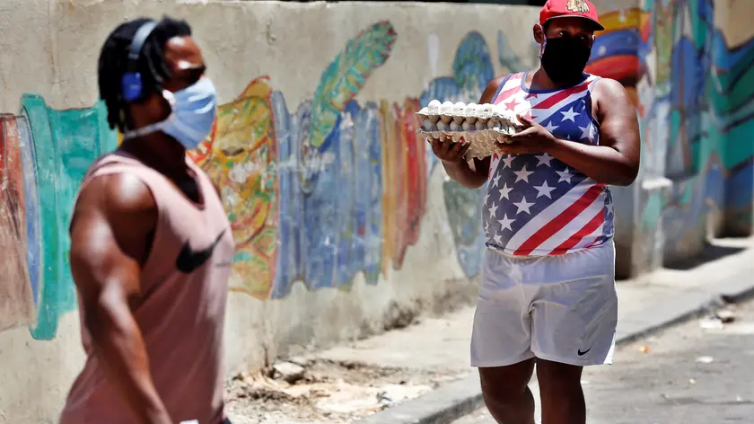 epa08374214 A man wearing a protective face mask carries eggs amid the ongoing coronavirus COVID-19 pandemic in Havana, Cuba, 20 April 2020. Countries around the world are taking increased measures to stem the widespread of the SARS-CoV-2 coronavirus which causes the COVID-19 disease. EPA/ERNESTO MASTRASCUSA