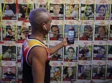 epa11492954 A man using a mobile phone takes pictures of Israeli hostages in captivity in Gaza during a protest outside the Kirya military headquarters in Tel Aviv, Israel, 23 July 2024. According to the Israeli military, 116 Israelis, who were abducted and taken to the Gaza Strip during the 07 October 2023 attacks by Hamas, remain in captivity. Rallies in Israel have been critical of the government's handling of the crisis, demanding the immediate release of all hostages. EPA/ABIR SULTAN