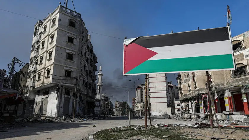 epa10948965 A billboard with a Palestinian flag stands next to damaged buildings after Israeli air strikes on Tel al-Hawa neighborhood, in Gaza City, 30 October 2023. The IDF struck over 600 militant targets over the past few days as it continued to 'expand ground operations' in the Gaza Strip, the Israel Defense Forces (IDF) said on 30 October. More than 8,000 Palestinians and at least 1,400 Israelis have been killed, according to the Israel Defense Forces (IDF) and the Palestinian health authority, since Hamas militants launched an attack against Israel from the Gaza Strip on 07 October, and the Israeli operations in Gaza and the West Bank which followed it. EPA/MOHAMMED SABER