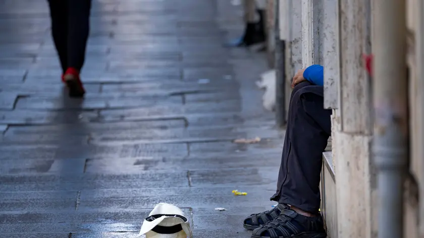 Un uomo chiede l’elemosina a Roma, 6 ottobre 2023. ANSA/MASSIMO PERCOSSI (Poverta', elemosina, clochard, barbone, senza tetto, bisognoso, bisognosi, solitudine)