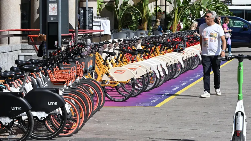 Una persona cammina accanto a una fila di bike-sharing esposte in una delle vie del centro, Milano, 7 settembre 2023. ANSA/DANIEL DAL ZENNARO