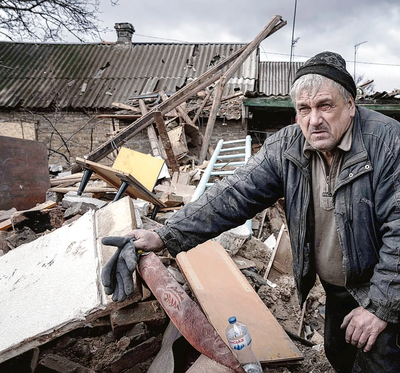 Mykola Volenshak checks his house that was destroyed by a Russian rocket as he tries to find documents under the rubble in Maxymilianivka village, Ukraine, Tuesday, Feb. 21, 2023. (AP Photo/Evgeniy Maloletka)