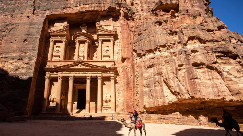 epa08498823 Jordan domestic tourists walk in front of the Treasury building at the reopened Petra archeological site, in Petra, some 280 km south of Amman, Jordan, 20 June 2020. Petra archeological site is one of the landmarks of Jordan tourism sector, the former Nabatean capital which dates back to about 200 BC, attracted in 2019, according to official figures, about 1,13 million visitors from all over the world. Following the start of the COVID-19 coronavirus pandemic in Jordan, the last tourist left Petra on 16 March. Since then its some 200 guides, 1,500 horse and donkey owners, hotels, restaurant and tourist stalls workers stayed without a fixed revenue. As Jordan tourism sites have officially reopened to domestic tourism on 16 June, locals flocked on 20 June to visit Petra in quiet surroundings without the big tourist buses. EPA/ANDRE PAIN