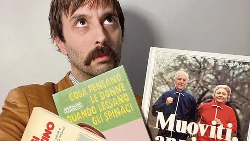 Auroro Borealo (Francesco Roggero) con tre pezzi della sua collezione di “libri brutti”