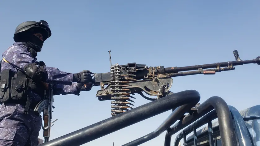 epa11071394 A Houthi soldier stands guard as people protest against a multinational operation to safeguard Red Sea shipping following Houthi attacks and the subsequent US and UK airstrikes on Houthis military sites, in Sanaa, Yemen, 12 January 2024. EPA/YAHYA ARHAB