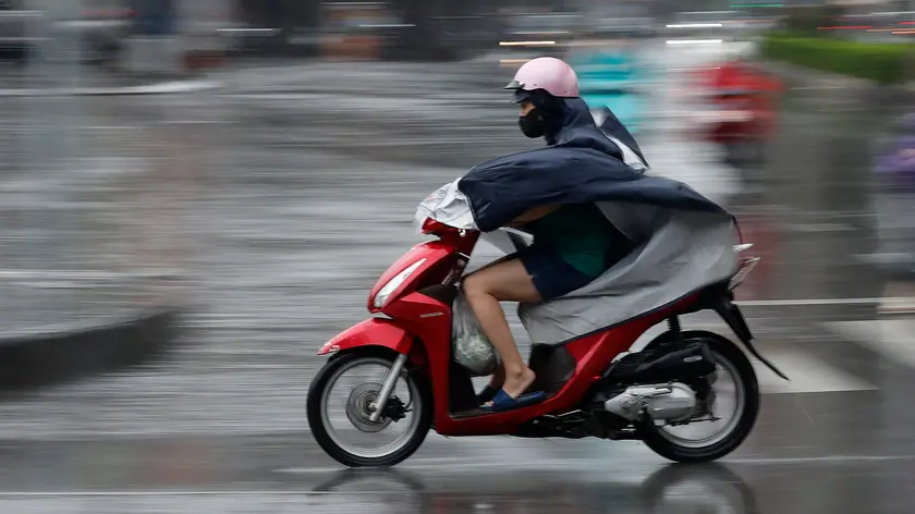 epa11590742 A woman rides a motorbike under the rain in Hanoi, Vietnam, 07 September 2024. Typhoon Yagi, Asia's most powerful storm so far this year, is expected to move deep into northern Vietnam after making landfall in Quang Ninh and Hai Phong on 07 September EPA/LUONG THAI LINH