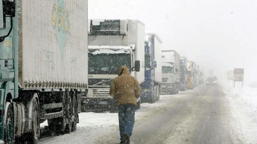 Lunga fila di Tir bloccati per la neve a Novi Ligure presso la bretella tra la A-26 e A-7 in una foto d'archivio. ANSA / Dino Ferretti