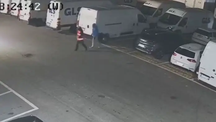 I due uomini con il volto travisato prima di entrare in azienda