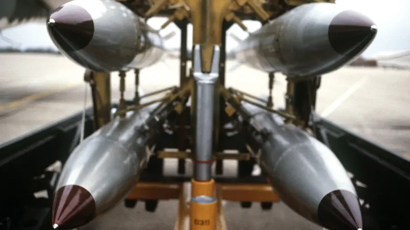 A front view of four nuclear free-fall bombs on a bomb cart.