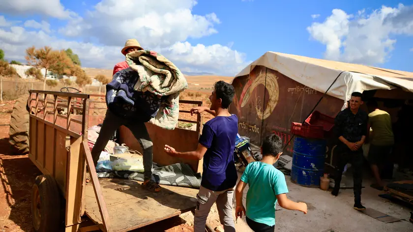 epa11606097 Syrian refugees load their belongings on a truck as they prepare to leave Wazzani village, southern Lebanon, 15 September 2024. Displaced Syrian refugees, who used to work in agricultural fields in Wazzani village, are leaving the area after leaflets reportedly dropped by the Israel Defense Forces (IDF) demanded the evacuation of civilians from the Wazzani area and surroundings by 4pm local time due to Hezbollah activity in the area. The IDF did not immediately issue an official comment about the evacuation recommendation. EPA/STR
