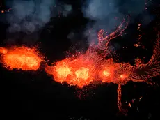 epa11037725 An aerial view taken with a drone shows lava and smoke spewing from a volcanic fissure during an eruption, near the town of Grindavik, in the Reykjanes peninsula, southwestern Iceland, 19 December 2023. The Icelandic Meteorological Office (IMO) announced the start of a volcanic fissure eruption near the Sundhnuka crater, north-east of Grindavik, on the night of 18 December, following weeks of intense earthquake activity in the area. The power and seismic activity of the eruption have decreased over time, IMO reported on 19 December, adding that since the eruption began, about 320 earthquakes have been recorded. EPA/ANTON BRINK