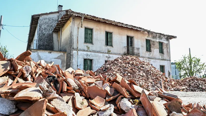 Mortegliano, un mese dopo: ancora un mucchio di tegole da raccogliere davanti alle case colpite dalla grandinata © Foto Petrussi