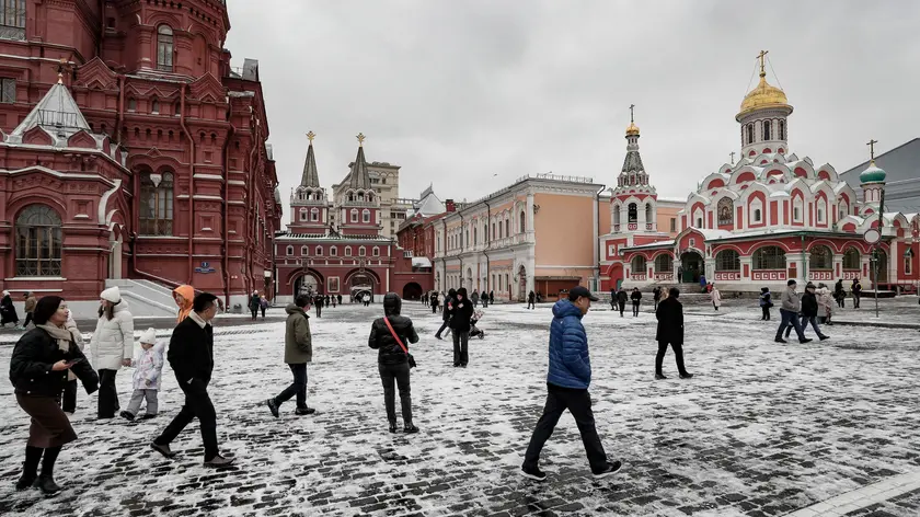 epa10943162 Pedestrians walk on a snow covered Red square after the first snowfall in Moscow, Russia, 27 October 2023. Temperatures in the Moscow region dropped to minus two degrees Celsius and are heralding winterly times to come. EPA/YURI KOCHETKOV