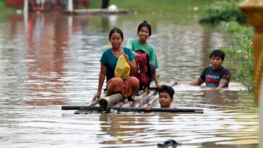 epa11603212 Flood victims wade through the flood waters with a makeshift raft during the flood in Taungoo, Bago division, Myanmar, 14 September 2024. Heavy rains triggered by Typhoon Yagi have caused severe flooding in parts of Myanmar, leaving thousands stranded in their homes, with further heavy rainfall and thunderstorms expected, according to the state weather office. A statement from the Military announced 59,413 households were affected in 34 townships and set up 187 relief camps for the 236,649 people. There were 33 casualties due to the flood in the country including the Naypyitaw. EPA/NYEIN CHAN NAING