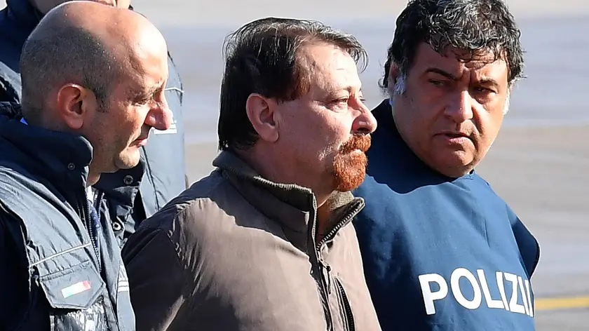 Former far-left militant Cesare Battisti arrives escorted by Italian police at Rome's Ciampino airport, Italy, 14 January 2019. Cesare Battisti, 64, a former member of the far-left terrorist group Armed Proletarians for Communism (PAC), was arrested in Bolivia after 38-years as a fugitive of the Italian justice. He is set to serve a life sentence for four murders committed in Italy's 'years of lead' of political violence in the 1970s and 1980s, media reported. ANSA/ETTORE FERRARI..
