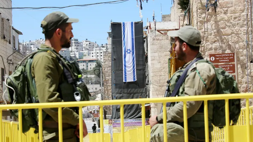 epa09891334 Israeli soldiers at a heavilly guarded checkpoint outside of the Ibrahimi mosque, or the Cave of the Patriarchs, as Muslims attend Friday Prayers in the West Bank city of Hebron, 15 April 2022. Muslims around the world celebrate the holy month of Ramadan, by praying during the night time and abstaining from eating, drinking, and sexual acts during the period between sunrise and sunset. Ramadan is the ninth month in the Islamic calendar and it is believed that the revelation of the first verse in Koran was during its last 10 nights. EPA/ABED AL HASHLAMOUN