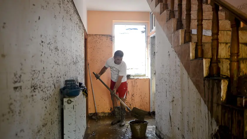 epa04336299 A picture made available 31 July 2014 shows a man cleaning up the water and mud from his family house in the flooded village of Bascov, Arges, Romania, 30 July, 2014. According to reports, more than 1,000 people were evacuated by 2,200 emergency workers, 63 villages from ten counties being affected by floods after heavy rains hit south-eastern Romania. About 400 houses were destroyed, one person died and four others are missing, authorities said. EPA/OCTAV GANEA ROMANIA OUT