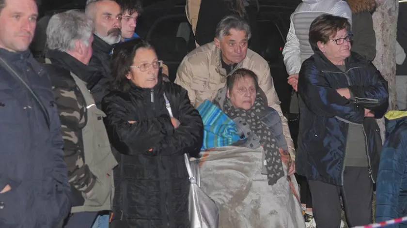 La moglie di Adelfino Pacorigh (con la coperta) impietrita davanti alla casa in fiamme (Foto Petrussi)