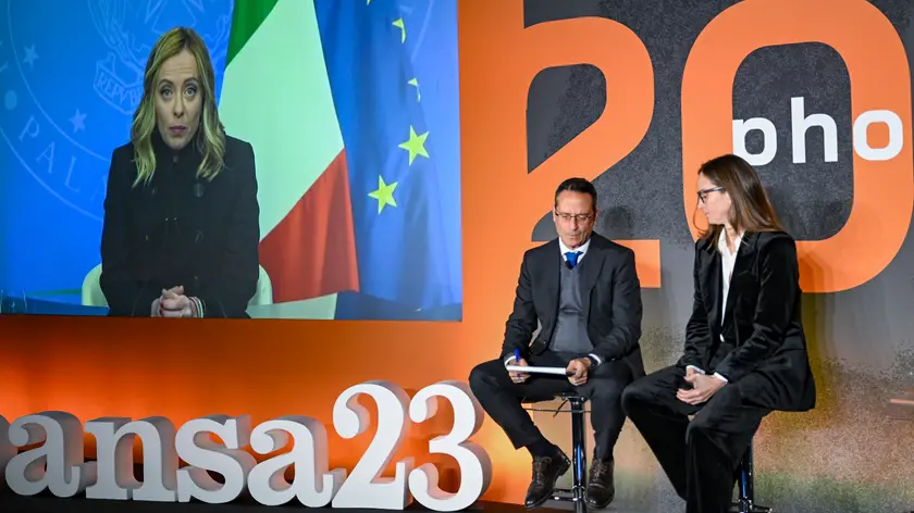 La presidente del consiglio Giorgia Meloni (video collegamento) intervistata Luigi Contu (S), direttore dell’ANSA e Silvia Gasparetto redazione politica ANSA, durante la presentazione del libro Photoansa 2023, l’annuale volume che raccoglie le migliori immagini scattate dai fotografi dell'ANSA, Roma 11 dicembre 2023. ANSA/ETTORE FERRARI