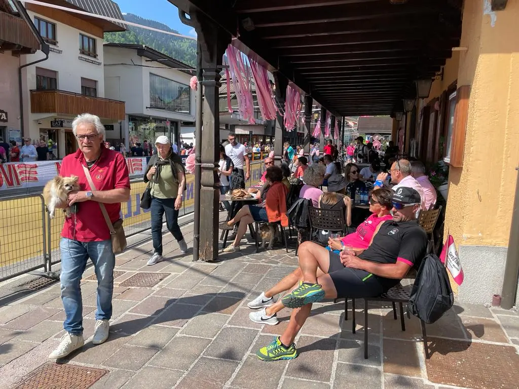 Splende il sole, intanto, in Friuli. Finalmente bel tempo sul Giro inseguito per giorni e giorni dalla pioggia nella sua risalita al Nord; spettacolo fino all’ultimo per una classifica apertissima come non mai. Tantissime le persone sulle strade, a Tarvisio e al Santuario, che applaudono i ciclisti ma soprattutto i due atleti friulani in gara, Alessandro De Marchi e Jonathan Milan, con la sua maglia ciclamino semplicemente passato in 21 tappe da esordiente a eroe acclamato da tutti e protagonista ieri dell’impresa del Giro arrivando in tempo massimo dopo una notte insonne. E poi turisti-tifosi in arrivo da Austria, soprattutto Slovenia per il loro Roglic; telespettatori incollati alle tv da tutto il mondo per assistere al debutto della misteriosa salita del Lussari, musica per le orecchie della Regione (Foto Petrussi)