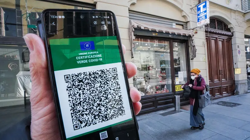 Una persona mostra il green pass sul cellulare davanti ad una rivendita di tabacchi in centro, Torino 18 gennaio 2022. ANSA/TINO ROMANO