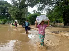 epa11601503 People carry their belonging as they wade through flood waters in Pyinmana, Naypyidaw, Myanmar, 13 September 2024. Heavy rains triggered by Typhoon Yagi have caused severe flooding in parts of Myanmar, leaving thousands stranded in their homes, with further heavy rainfall and thunderstorms expected, according to the state weather office. EPA/NYEIN CHAN NAING