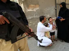 epa11599890 A police officer stands guard as a health worker administers polio vaccine drops to a child during a door-to-door vaccination campaign in Peshawar, Pakistan, 12 September 2024. A polio vaccination worker and a police officer providing security were killed during a polio vaccination campaign near the Afghan border in Bajaur district, Khyber Pakhtunkhwa, on 11 September 2024, after an attack by suspected militants. The police cordoned off the area and initiated a search operation for the attackers, while the bodies were taken to Khar Hospital. This incident highlights the ongoing violence aimed at disrupting polio eradication efforts in the region, despite existing security measures. Pakistan is one of the last two countries, along with Afghanistan, where the polio is still endemic, meaning infections occur within the local population or within a particular area. EPA/ARSHAD ARBAB