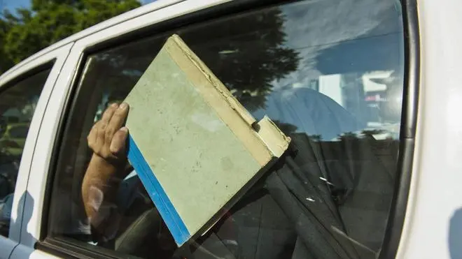 epa03585229 A document folder shields the face of South African paralympic and Olympic sprinter, Oscar Pistorius as he arrives in a police vehilce at the Pretoria magistrates court after spending the night in police custody in Pretoria, South Africa 15 February 2013. Pistorius has been officially charged with murder. He was arrested 14 February 2013 for allegedly shooting and killing his girlfriend Reeva Steenkamp at his home in the Silverwoods security estate in Pretoria, South Africa. EPA/STR