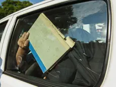 epa03585229 A document folder shields the face of South African paralympic and Olympic sprinter, Oscar Pistorius as he arrives in a police vehilce at the Pretoria magistrates court after spending the night in police custody in Pretoria, South Africa 15 February 2013. Pistorius has been officially charged with murder. He was arrested 14 February 2013 for allegedly shooting and killing his girlfriend Reeva Steenkamp at his home in the Silverwoods security estate in Pretoria, South Africa. EPA/STR