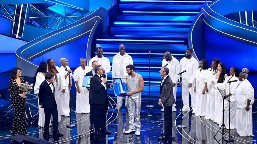 Italain singer Marco Mengoni receives a trophy for the best cover by Liguria Region President Giovanni Toti with Sanremo Festival host and artistic director Amadeus on stage at the Ariston theatre during the 73rd Sanremo Italian Song Festival, in Sanremo, Italy, 10 February 2023. The music festival will run from 07 to 11 February 2023. ANSA/RICCARDO ANTIMIANI