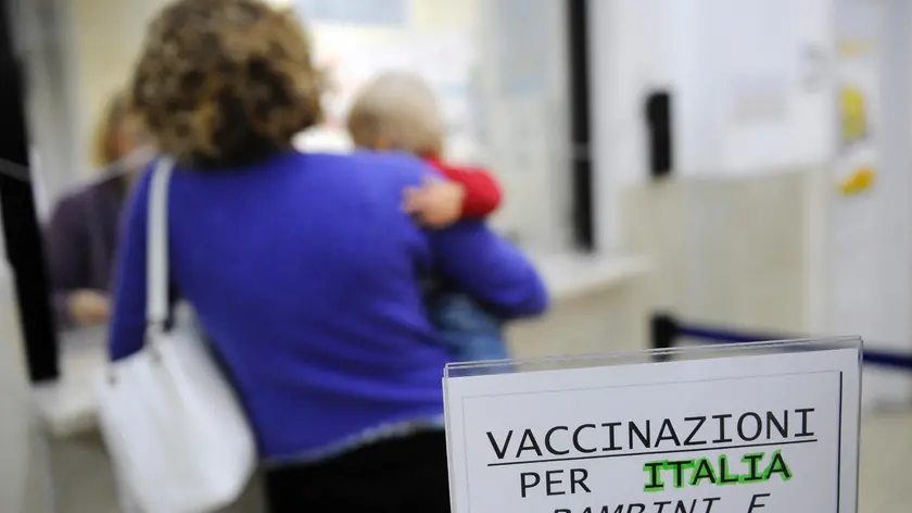 Una madre con il figlio in braccio chiede informazioni sulla somministrazione del vaccino contro l'H1n1 a uno degli sportelli dell'Asl di via Statuto, Milano, 2 novembre 2009. ANSA/DANIEL DAL ZENNARO