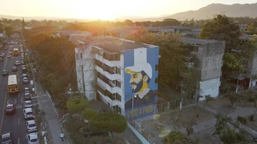 epa11116398 Aerial photograph of a mural alluding to President Nayib Bukele on the facade of a multi-family building, in San Salvador, El Salvador, 31 January 2024. The candidates for the Presidency of El Salvador put an end to a long electoral campaign that began on 03 October 2023 and during which there has hardly been any political debate, largely because the current president Nayib Bukele starts as the great favorite, with more than 80%, according to surveys. EPA/VLADIMIR CHICAS