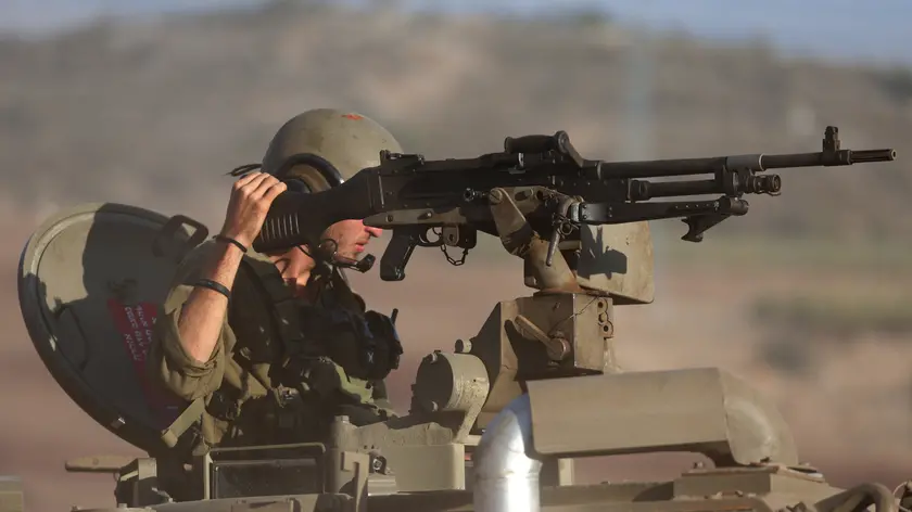 epa10940553 An Israeli soldier in a Merkava tank during maneuvers at an undisclosed location along the border with Lebanon, in Israel, 26 October 2023. Tensions remain high at the border between Israel and Lebanon after the Israeli-Palestinian conflict escalated following an unprecedented attack carried out by Hamas militants from Gaza into Israel on 07 October 2023. EPA/ATEF SAFADI