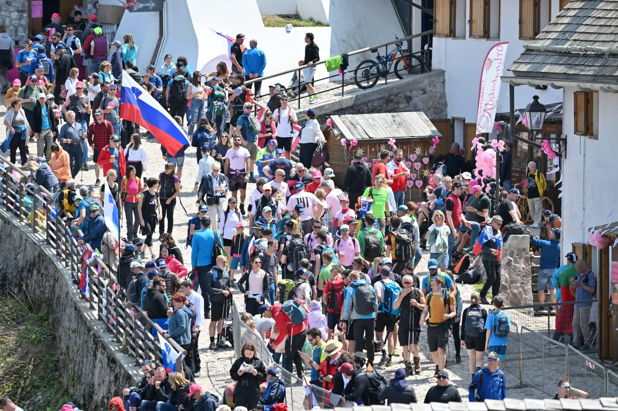 Splende il sole, intanto, in Friuli. Finalmente bel tempo sul Giro inseguito per giorni e giorni dalla pioggia nella sua risalita al Nord; spettacolo fino all’ultimo per una classifica apertissima come non mai. Tantissime le persone sulle strade, a Tarvisio e al Santuario, che applaudono i ciclisti ma soprattutto i due atleti friulani in gara, Alessandro De Marchi e Jonathan Milan, con la sua maglia ciclamino semplicemente passato in 21 tappe da esordiente a eroe acclamato da tutti e protagonista ieri dell’impresa del Giro arrivando in tempo massimo dopo una notte insonne. E poi turisti-tifosi in arrivo da Austria, soprattutto Slovenia per il loro Roglic; telespettatori incollati alle tv da tutto il mondo per assistere al debutto della misteriosa salita del Lussari, musica per le orecchie della Regione (Foto Petrussi)