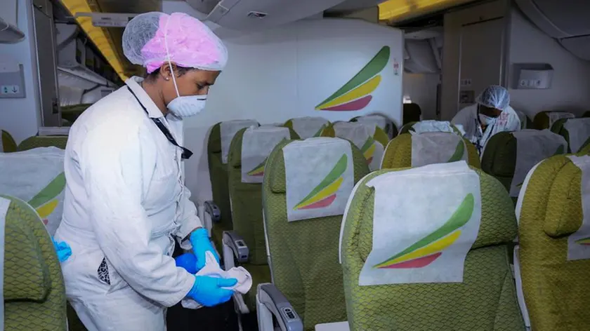 Una addetta disinfetta la cabina di un volo Ethiopian Airlines