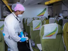 Una addetta disinfetta la cabina di un volo Ethiopian Airlines