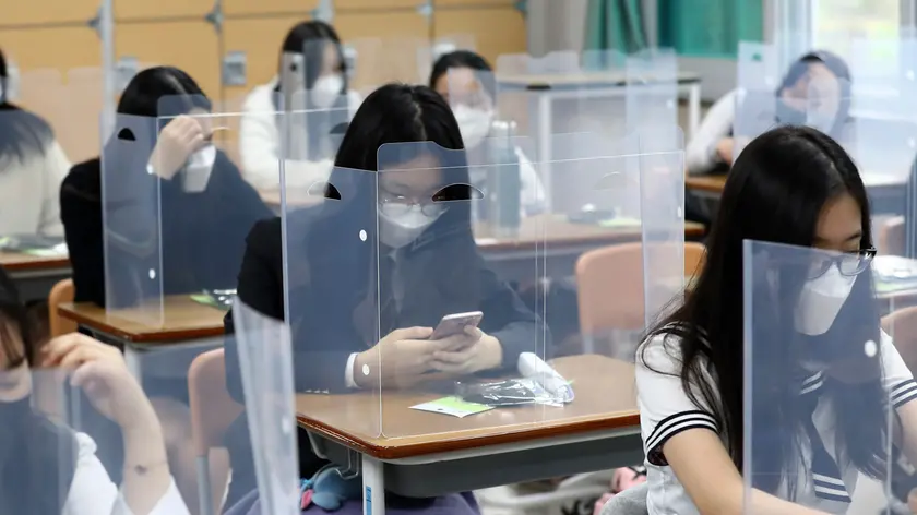 Senior students wait for class to begin with plastic boards placed on their desks at Jeonmin High School in Daejeon, South Korea, Wednesday, May 20, 2020. South Korean students began returning to schools Wednesday as their country prepares for a new normal amid the coronavirus pandemic. (Kim Jun-beom/Yonhap via AP)