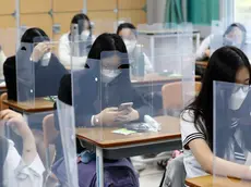Senior students wait for class to begin with plastic boards placed on their desks at Jeonmin High School in Daejeon, South Korea, Wednesday, May 20, 2020. South Korean students began returning to schools Wednesday as their country prepares for a new normal amid the coronavirus pandemic. (Kim Jun-beom/Yonhap via AP)